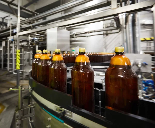 飲料ビール工場のコンベアベルトの新しいペットボトル。飲料水製造プロセス。浅いドーフ。選択フォーカス — ストック写真