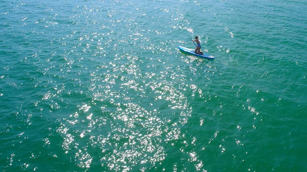 空中无人机鸟眼看年轻女子在碧绿的热带清澈的海水中行使棋盘 — 图库照片