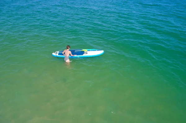 Aerial drone birds eye view of young woman exercising sup board in turquoise tropical clear waters — Stock Photo, Image