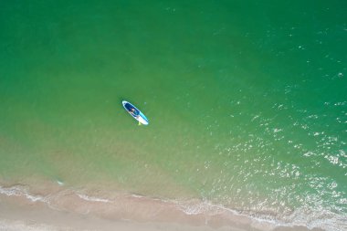 Tropik sahilde Sup tahtasında kürek çeken genç bir kadın. Paddle board ile aktif yaz tatilleri.