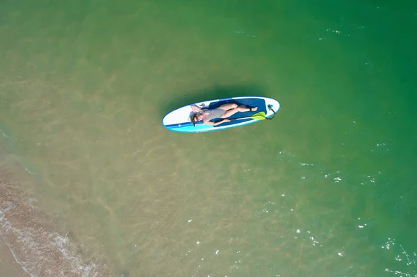 Férias de Verão. Mulher bonita Relaxando no SUP na água azul-turquesa. Beleza, bem-estar. Recreação . — Fotografia de Stock