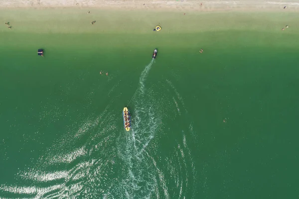 Un bateau de banane plein de touristes excès de vitesse loin — Photo