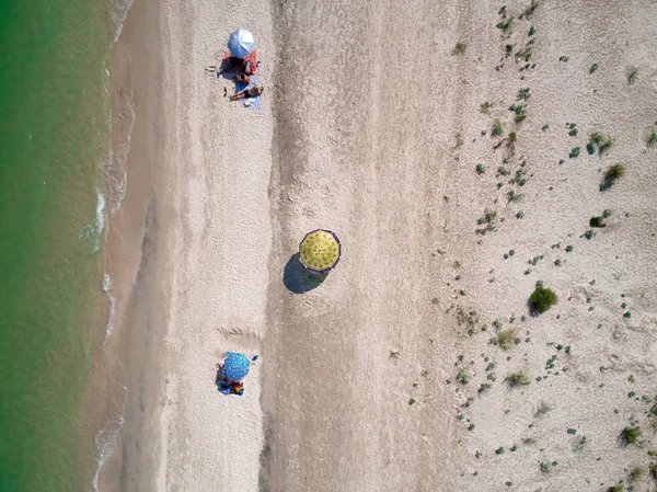 Strand met toeristen, ligbedden en parasols. zee reisbestemming. vakantie achtergrond. bovenaanzicht. — Stockfoto