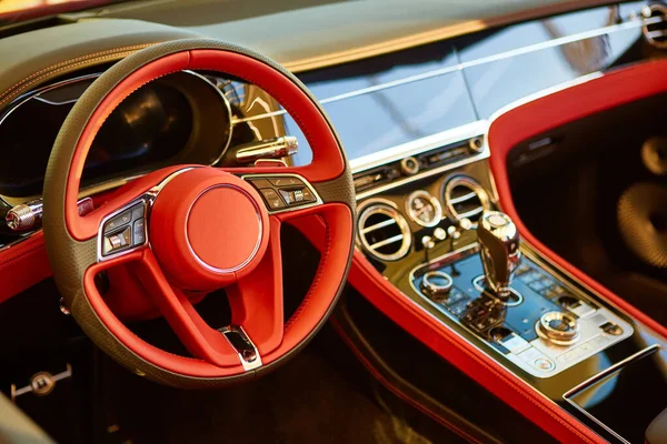 Interior rojo coche de lujo. Volante, palanca de cambios y tablero de instrumentos. Casquillo superficial —  Fotos de Stock