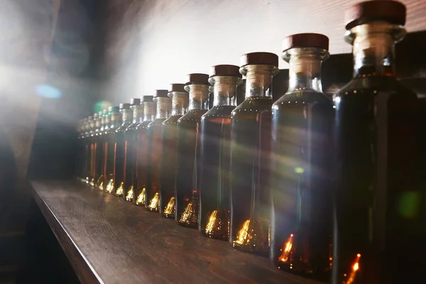 Kleurschaal gradatie van whiskey en cognac infusie in flessen. fles rangschikking op leeftijd tijd. — Stockfoto