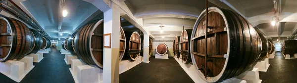 Old private wine cellar with many oak barrels, equipment for wine production. Old oak barrels in cellar — Stock Photo, Image