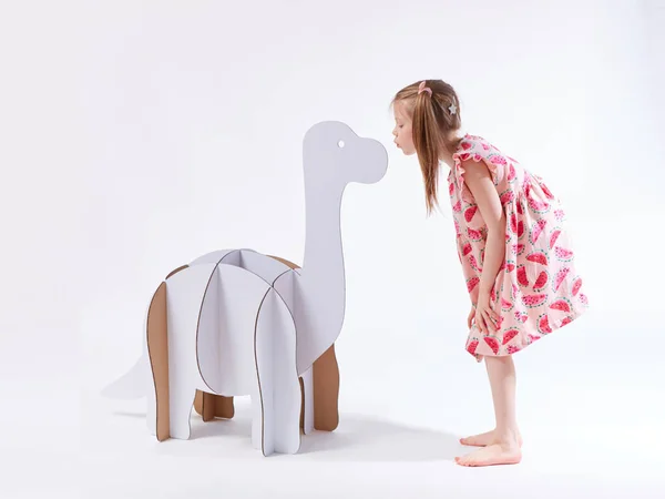 Niña soñadora jugando con un dinosaurio de cartón Brontosaurus. Infancia. Fantasía, imaginación — Foto de Stock