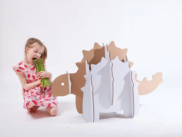 Petite fille rêveuse jouant avec un dinosaure en carton Ankylosaure. Enfance. Fantaisie, imagination . — Photo