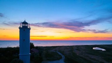 Güzel gece deniz manzarası Deniz feneri ve karamsar gökyüzü gün batımında