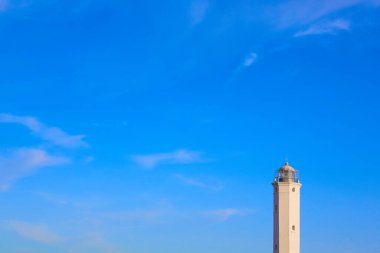 Güneşli bir günde mavi gökyüzü olan beyaz güvercin noktası deniz feneri