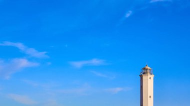 Güneşli bir günde mavi gökyüzü olan beyaz güvercin noktası deniz feneri