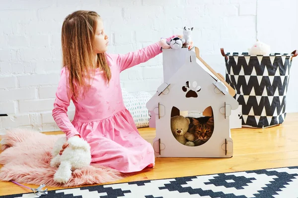La muchacha juega con el gatito, el interior — Foto de Stock
