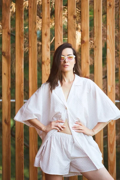 Vrouw in pyjama over houten achtergrond op terras. Goedemorgen concept — Stockfoto