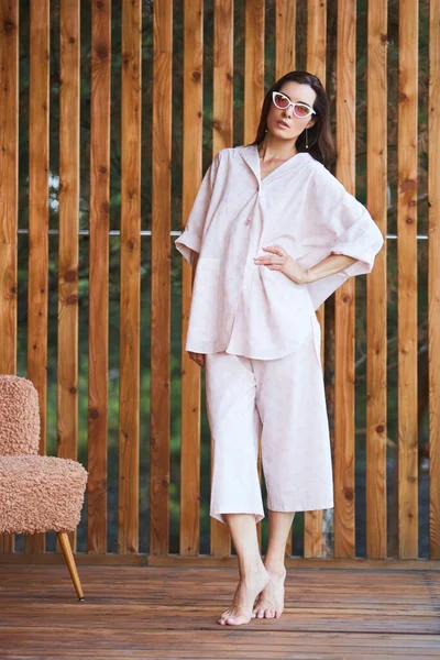 Vrouw in pyjama over houten achtergrond op terras. Goedemorgen concept. — Stockfoto