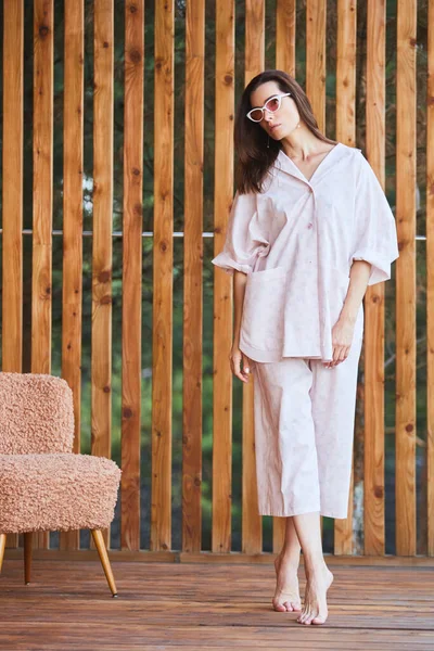 Kobieta w piżamie na drewnianym tle na tarasie. Dzień dobry.. — Zdjęcie stockowe