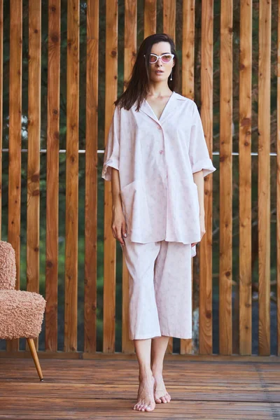 Femme en pyjama sur fond bois sur terrasse. Bonjour concept. — Photo
