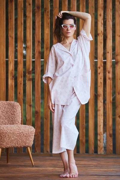 Vrouw in pyjama over houten achtergrond op terras. Goedemorgen concept. — Stockfoto