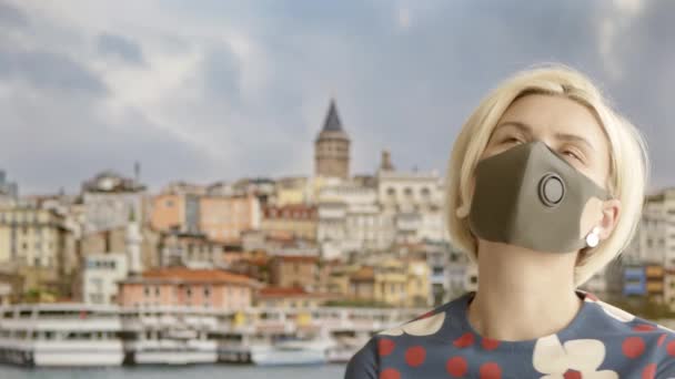 Frau mit Schutzmaske zu Hause, die vorgibt, auf Reisen zu sein. Posieren auf dem Hintergrundbildschirm. Sommerquarantäne 2020. Zuhause bleiben und soziale Distanz wahren — Stockvideo