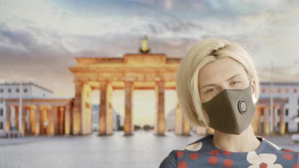 Een vrouw met een veilig masker thuis die doet alsof ze op reis is. Poseren op achtergrond TV scherm. 2020 zomer quarantaine reizen. Blijf thuis en sociale afstand — Stockvideo