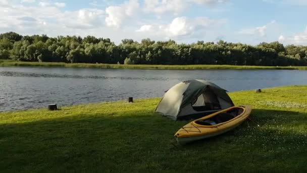 Time Lapse utsikt över tältet och gul kajak på stranden floden. Små moln vid horisonten. — Stockvideo