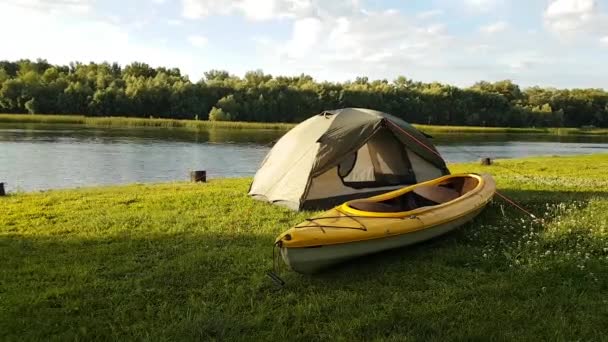 Time Lapse utsikt över tältet och gul kajak på stranden floden. Små moln vid horisonten. — Stockvideo