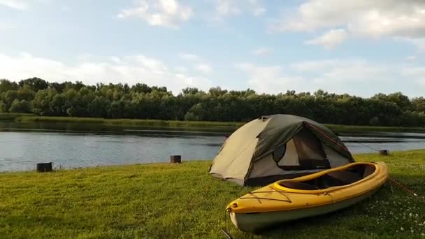 Time Lapse utsikt över tältet och gul kajak på stranden floden. Små moln vid horisonten. — Stockvideo
