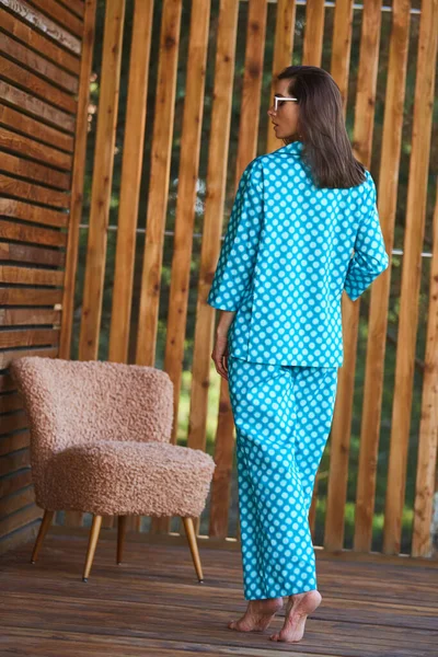 Femme debout en pyjama pyjama à pois sur fond bois en pleine longueur. Modèle féminin caucasien. — Photo