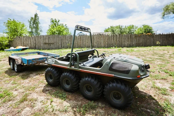 Vehículo todoterreno de ocho ruedas con remolque en un prado en un día de verano — Foto de Stock