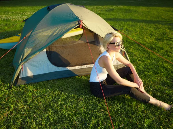 Reizen, kajakken en wandelen concept. Portret van een mooie jonge vrouw in de buurt van een groene tent met kajak bij de rivier. — Stockfoto