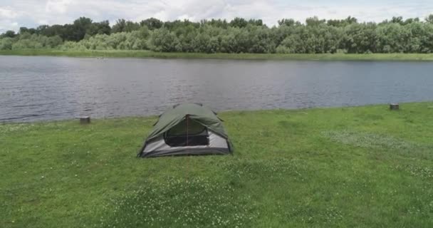 Кемпинг зеленая палатка в лесу возле озера — стоковое видео