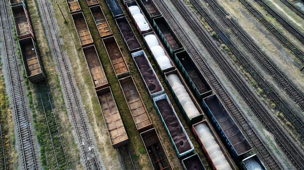 Luchtfoto van het station voor het sorteren van het goederenvervoer per spoor met treinwagons, met veel spoorbanen. Zware industrie. — Stockfoto