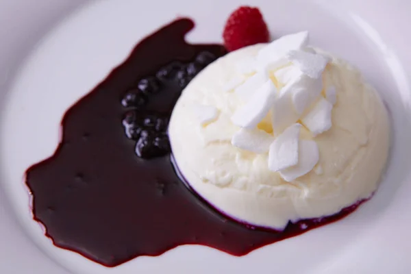 Panna cotta en plato blanco con salsa de bayas — Foto de Stock