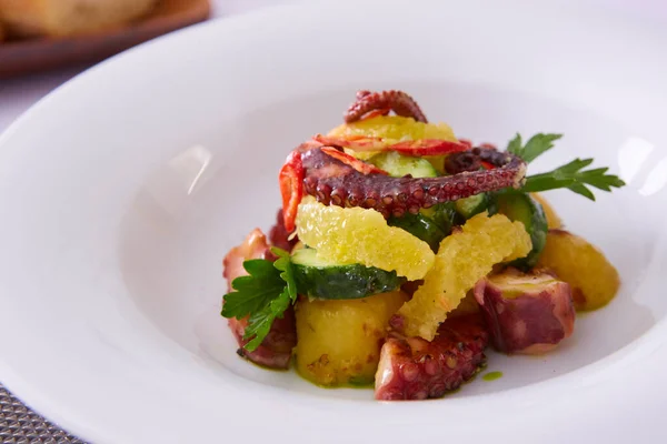 Whole octopus salad with orange and cress salad on white plate. Shallow dof — Stock Photo, Image