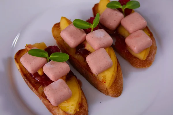 Předkrm. Foie Gras s mangem a malinami na chlebu. Mělké dof. — Stock fotografie