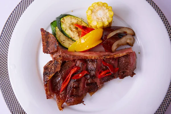 Steak vom Grill mit Gewürzen auf weißem Teller. Köstliches Essen im Restaurant. Oberflächlicher Dof. — Stockfoto