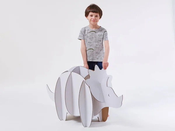 En liten drömpojke som leker med en dinosaurie Triceratops. Barndom. Fantasi, fantasi. — Stockfoto