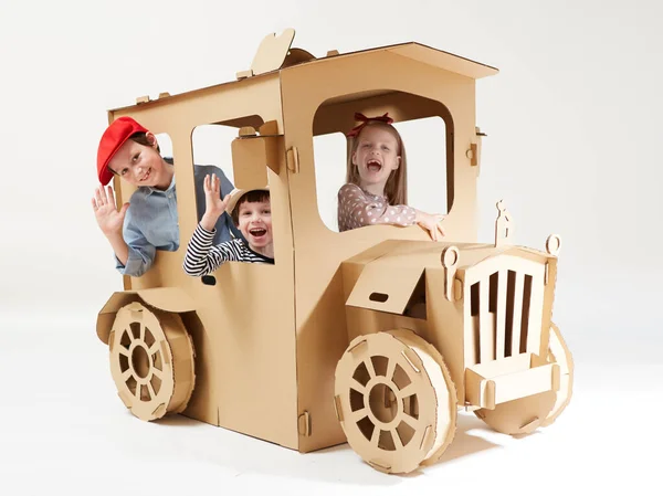 Творческие дети играют в картонную автомобильную игру. — стоковое фото