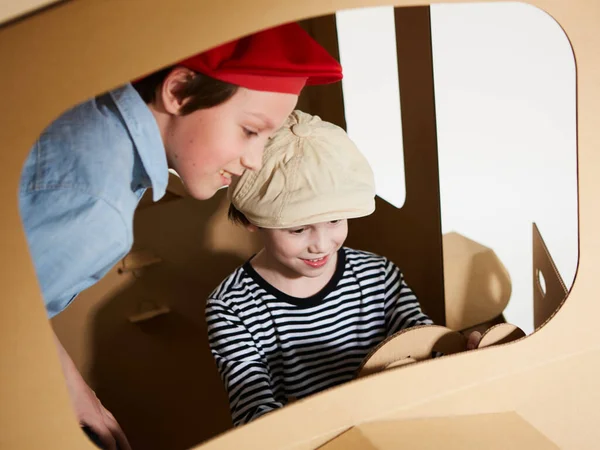 Творческие дети играют в картонную автомобильную игру. — стоковое фото
