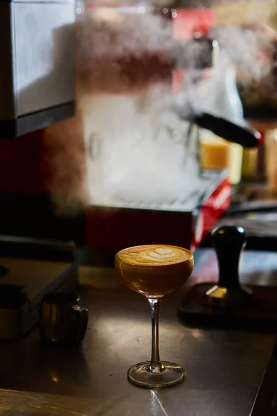 Café Latte ou café Piccolo com forma de coração de arte latte em um copo de martini ou coquetel. Dof rasa. — Fotografia de Stock