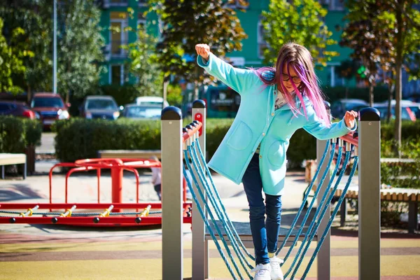 Attractive little girl on outdoor playground equipment — Stock Photo, Image