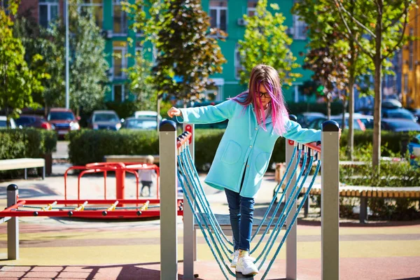 Attraktiv liten flicka på utomhus lekplats utrustning — Stockfoto