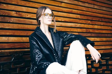 Koyu renk saçlı güzel bir kadının gözlüklü portresi.