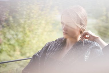 Havalı sonbahar kıyafeti giyen çekici, şehvetli genç bir kadının açık hava moda portresi. Ön planda güneş ışığı. Sığ dof