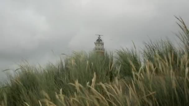 嵐の間に隠された灯台とテセル島の強い吹き砂丘草 — ストック動画