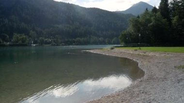 Arka planda dağlarla birlikte gökyüzündeki bulutlar sırasında doğadaki renkli göl. Düşük açı geniş açı..