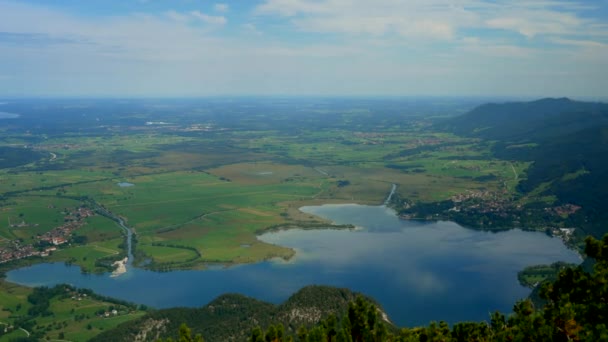 空とミュンヘンを背景に雲の風景とコチェルシー湖と農村風景の美しい空中パノラマショット ドイツのバイエルン州 ストック動画