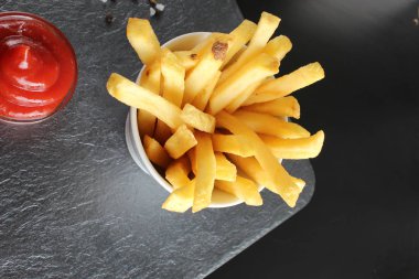 patates kızartması ve ketçap karanlık bir arka plan üzerinde