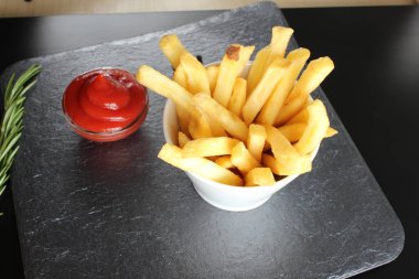 patates kızartması ve ketçap karanlık bir arka plan üzerinde