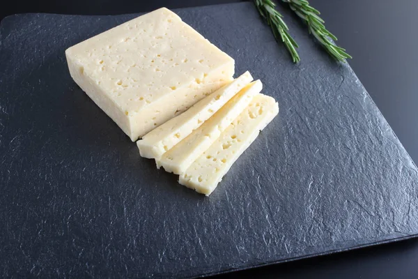 Taş Karanlık Bir Arka Plan Üzerinde Peynir Kesti — Stok fotoğraf