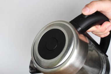 hafif bir arka plan üzerinde elinde elektrikli su ısıtıcısı